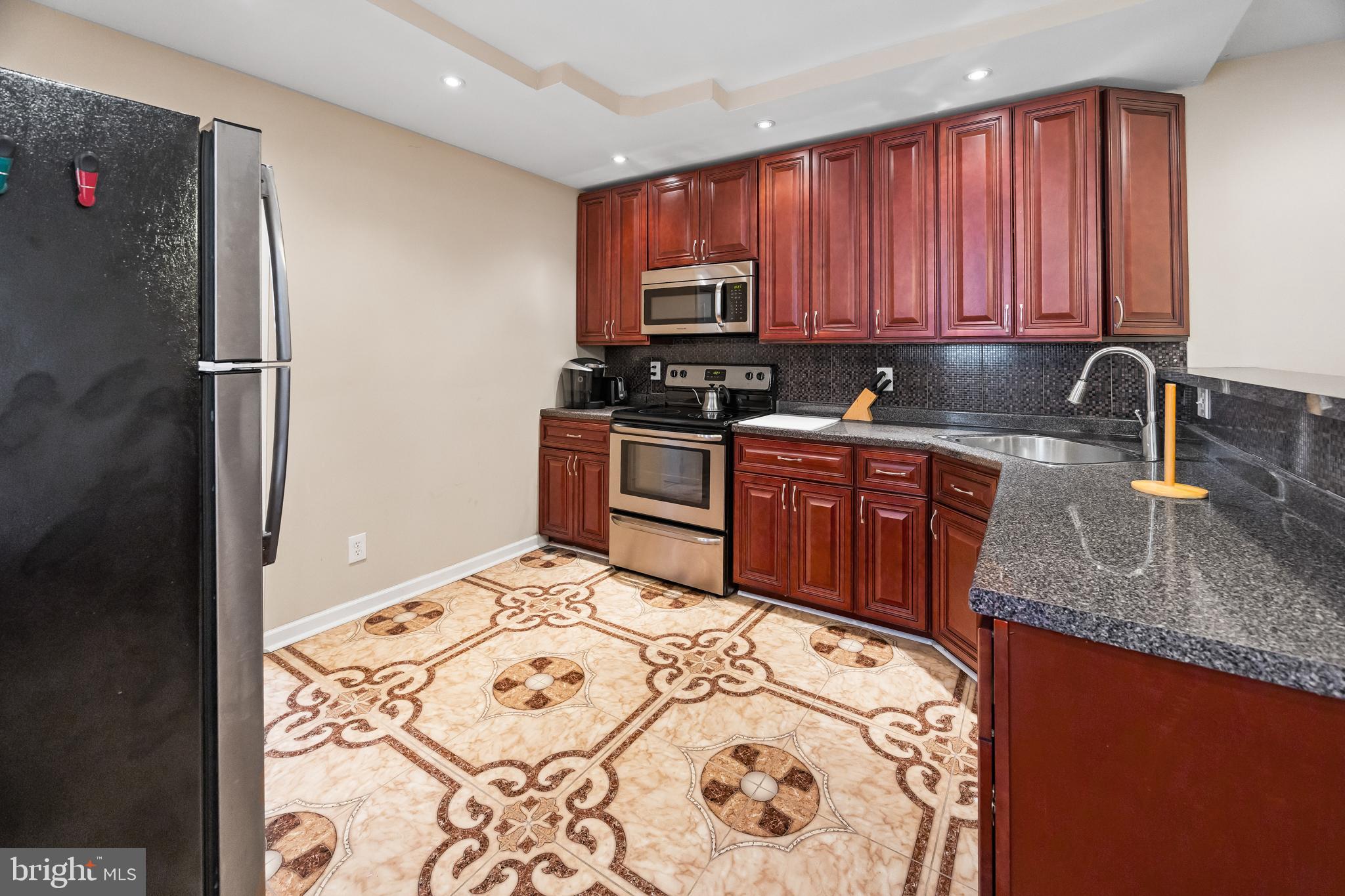 1837 73rd Avenue Philadelphia, PA 19126 - Photo 7 of 19 a kitchen with stainless steel appliances granite countertop a sink stove and refrigerator