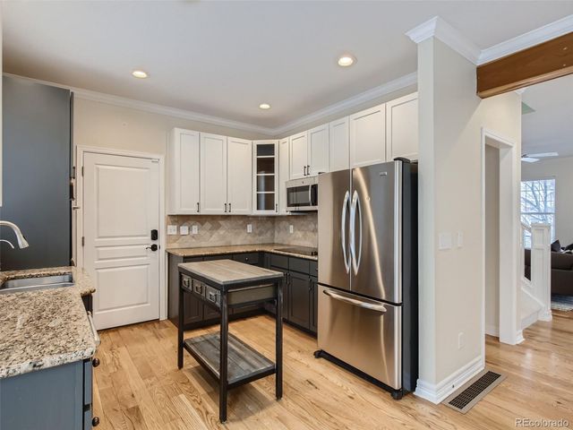a kitchen with stainless steel appliances granite countertop a refrigerator and a stove top oven