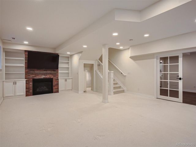 a view of an empty room with a fireplace and a window