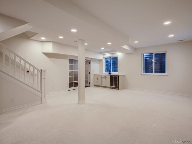 a view of an empty room with kitchen and window