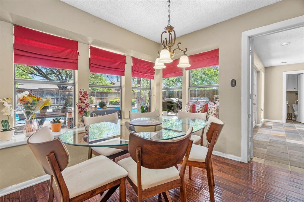 5107 Racquet Club Drive Arlington, TX 76017 - Photo 18 of 40 a dining room with wooden floor a chandelier a wooden table and chairs