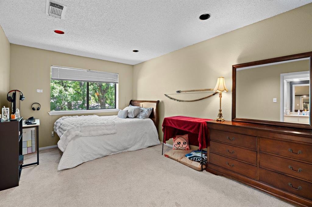 5107 Racquet Club Drive Arlington, TX 76017 - Photo 19 of 40 a bedroom with a bed and a dresser