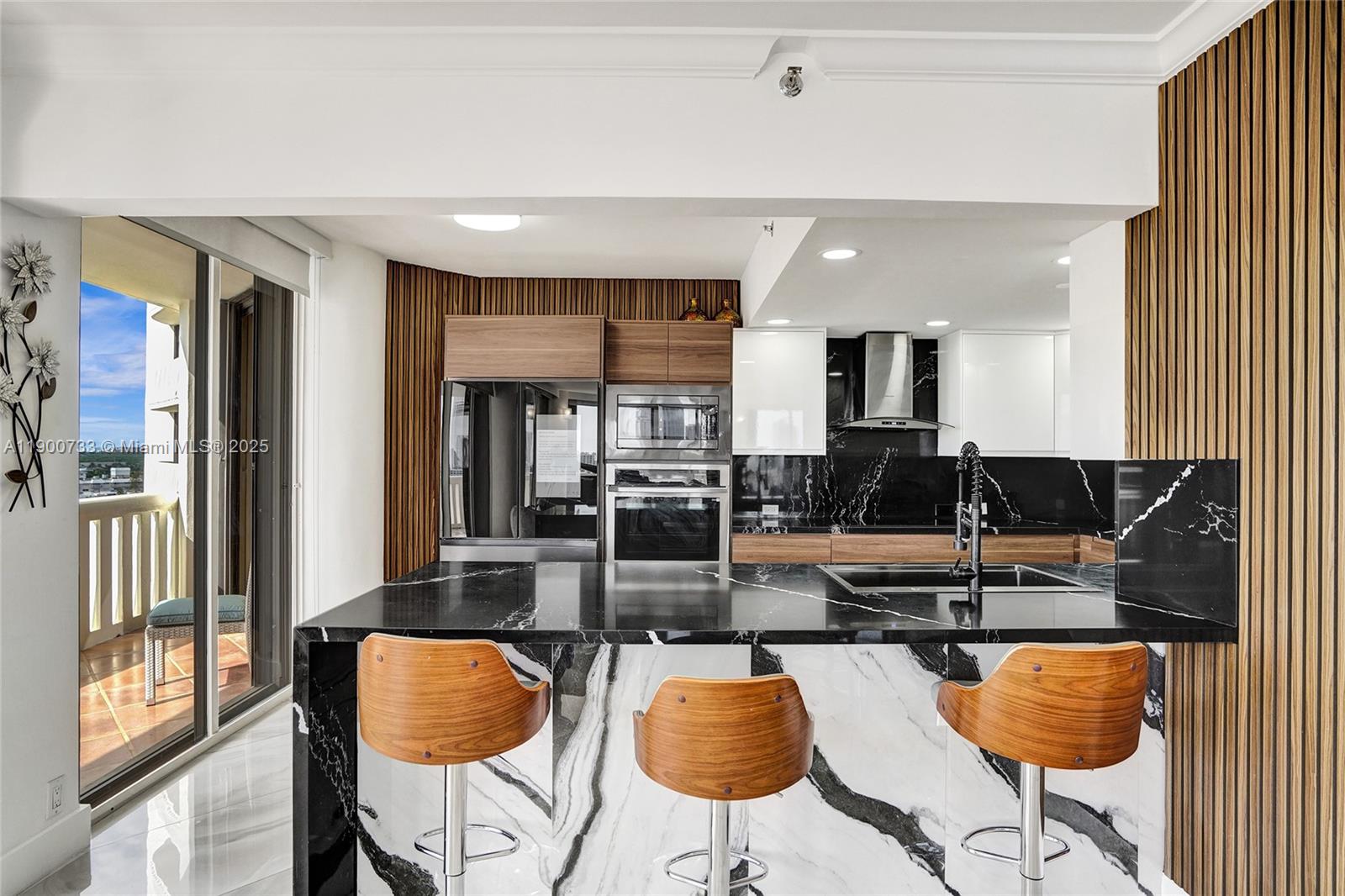 3000 Island Boulevard, Unit 1106 Aventura, FL 33160 - Photo 21 of 71 a kitchen with stainless steel appliances kitchen island granite countertop a table and chairs in it