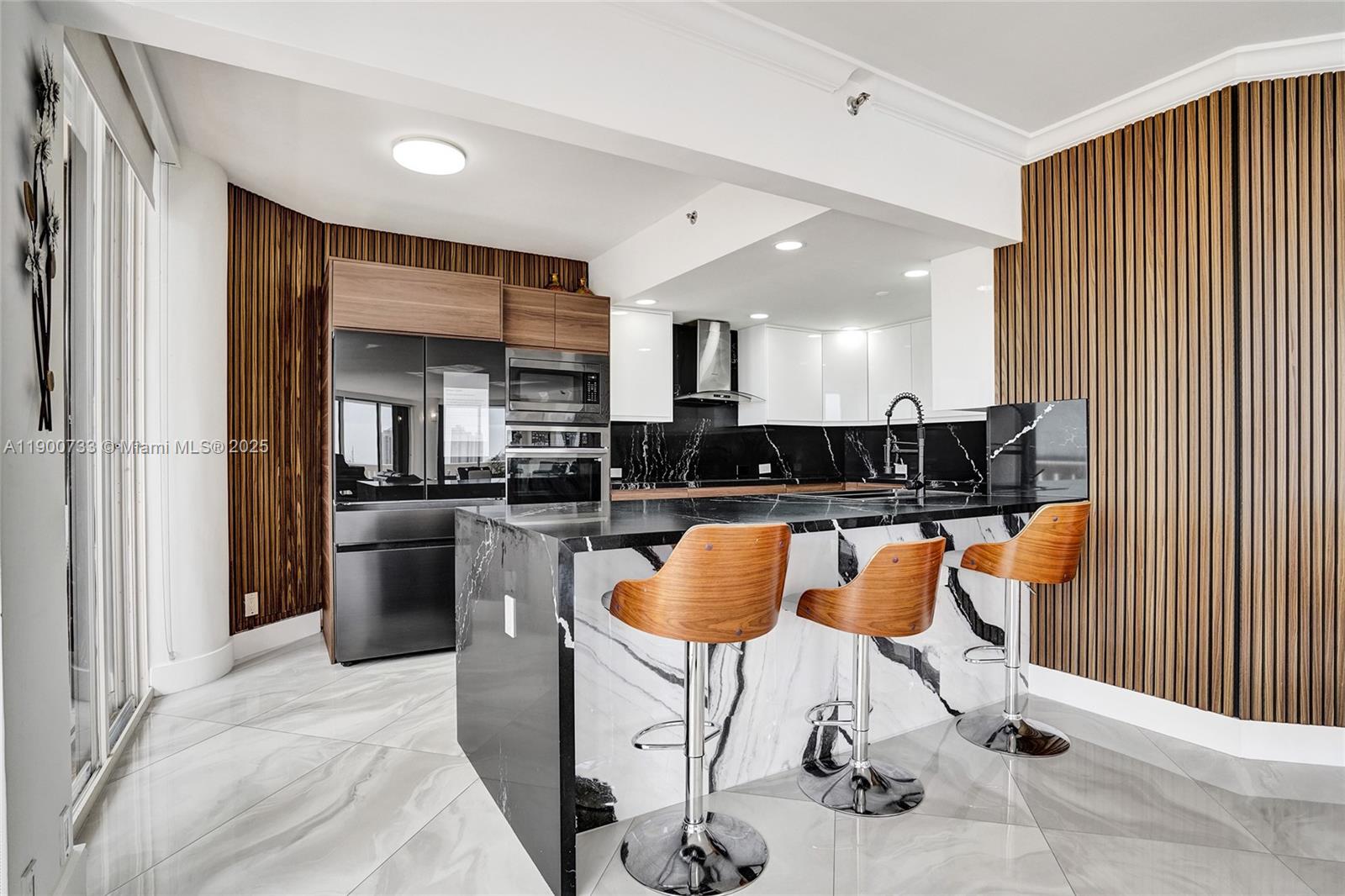 3000 Island Boulevard, Unit 1106 Aventura, FL 33160 - Photo 22 of 71 a kitchen with stainless steel appliances kitchen island granite countertop a refrigerator and a stove top oven