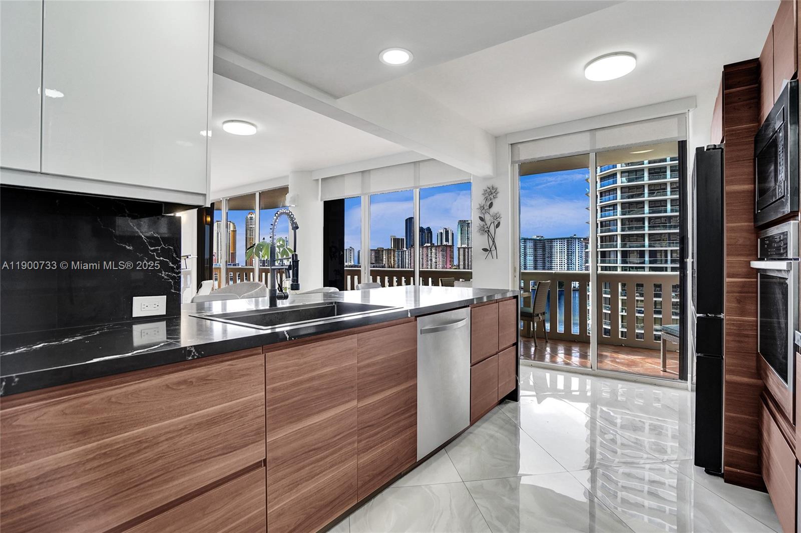 3000 Island Boulevard, Unit 1106 Aventura, FL 33160 - Photo 27 of 71 a kitchen with stainless steel appliances granite countertop a refrigerator and a sink