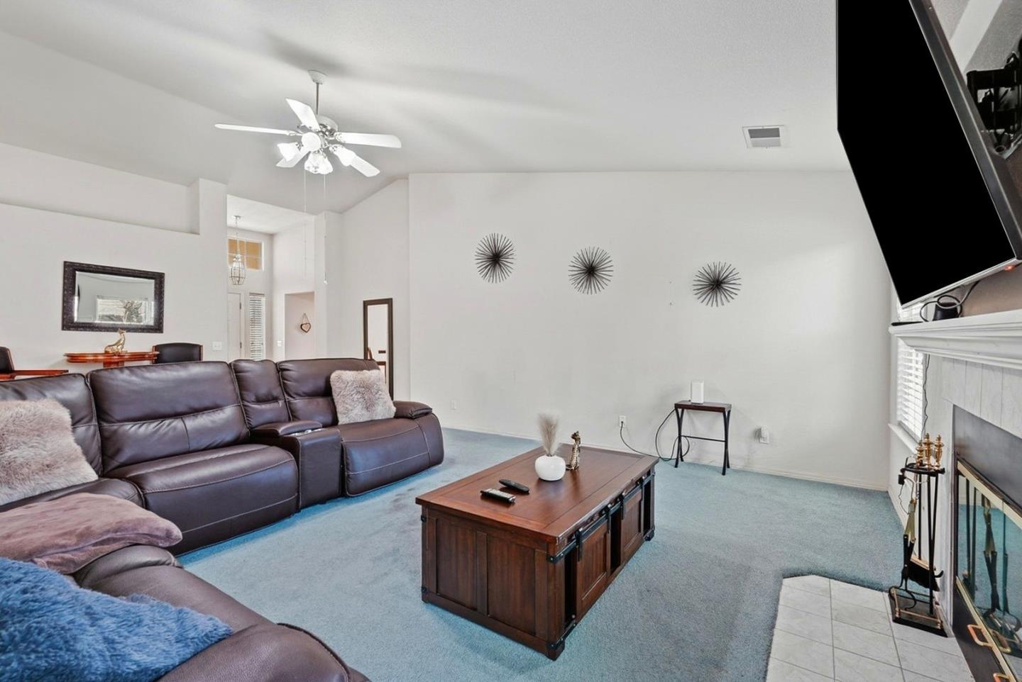 3882 Pintail Court Merced, CA 95340 - Photo 6 of 21 a living room with furniture a flat screen tv and a fireplace