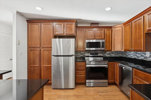a kitchen with stainless steel appliances granite countertop a refrigerator stove and microwave