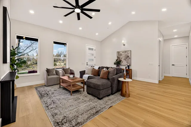 a kitchen with stainless steel appliances kitchen island a table chairs in it and white cabinets