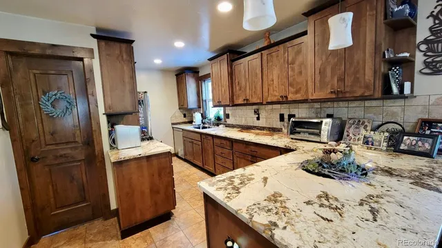 a kitchen with stainless steel appliances granite countertop a sink a stove and a cabinets