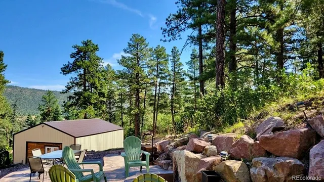 a view of a patio with table and chairs and a large tree