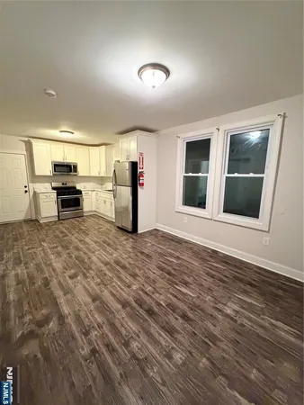 a kitchen with stainless steel appliances kitchen island granite countertop a sink a stove and microwave