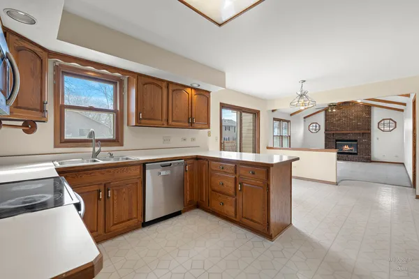 a kitchen with stainless steel appliances granite countertop a stove a sink dishwasher and a microwave oven with white cabinets