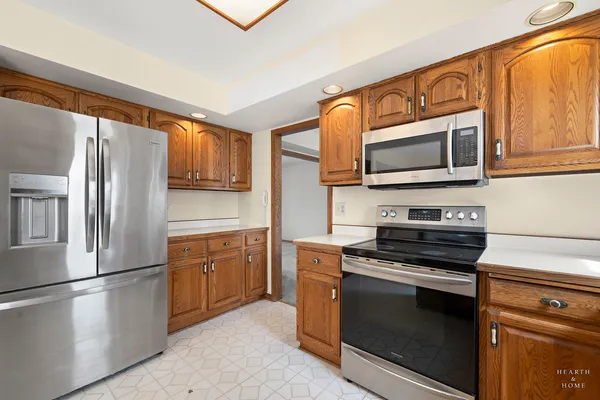 a kitchen with stainless steel appliances granite countertop a refrigerator microwave and stove top oven
