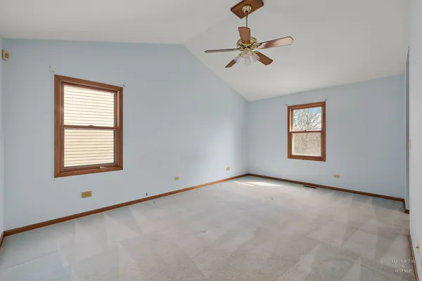 an empty room with a window and a ceiling fan