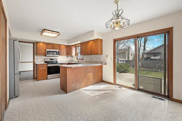 a kitchen with stainless steel appliances granite countertop a stove top oven a sink and a refrigerator