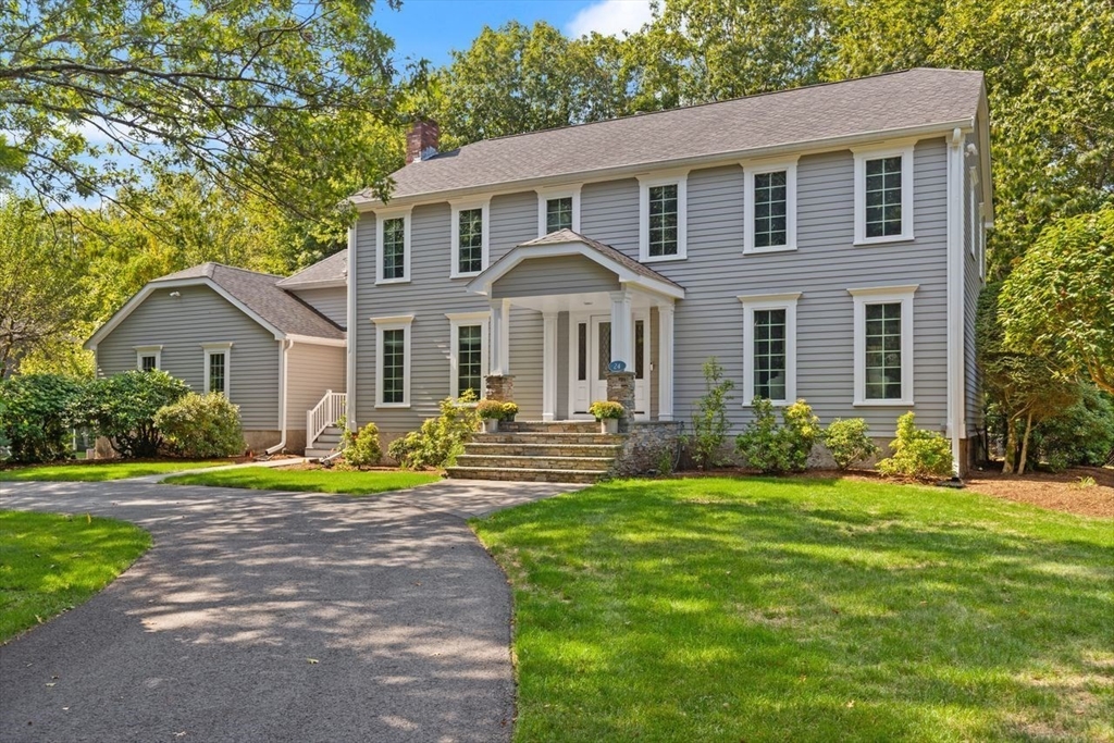 a front view of a house with a yard and trees