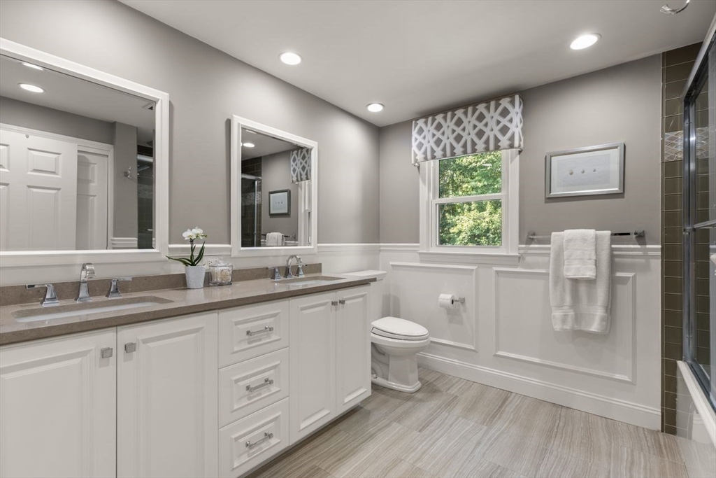 24 Queens Circle Sharon, MA 02067 - Photo 32 of 41 a bathroom with a granite countertop toilet a sink and a large mirror