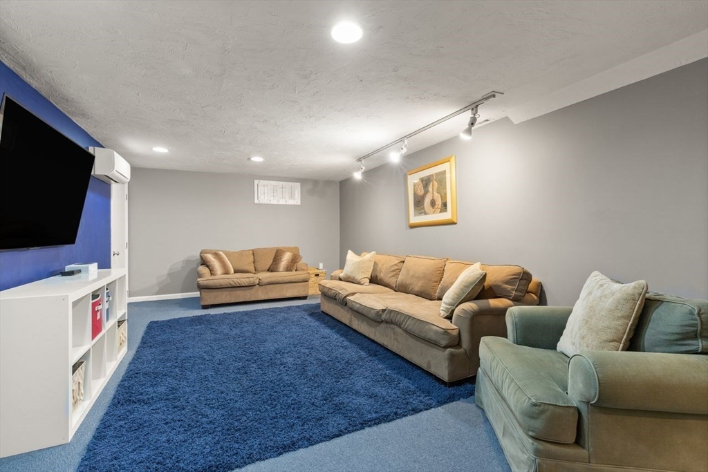 24 Queens Circle Sharon, MA 02067 - Photo 33 of 41 a living room with furniture and a flat screen tv