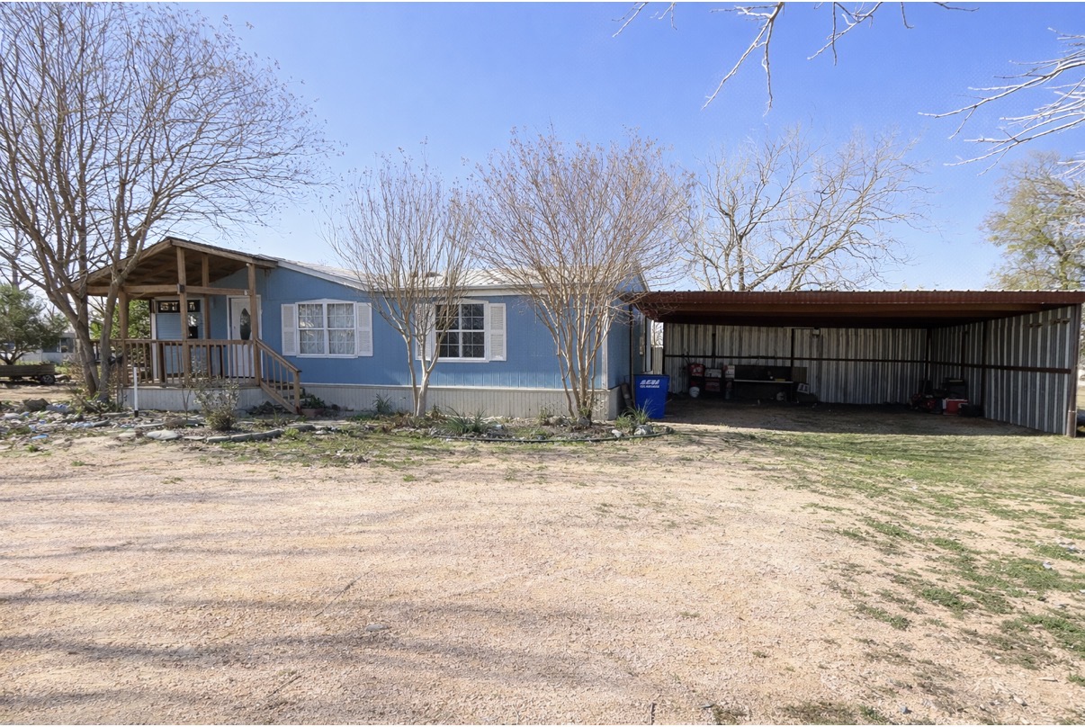 709 North 5th Street Jarrell, TX 76537 - Photo 2 of 3 View of side of property featuring a carport and driveway