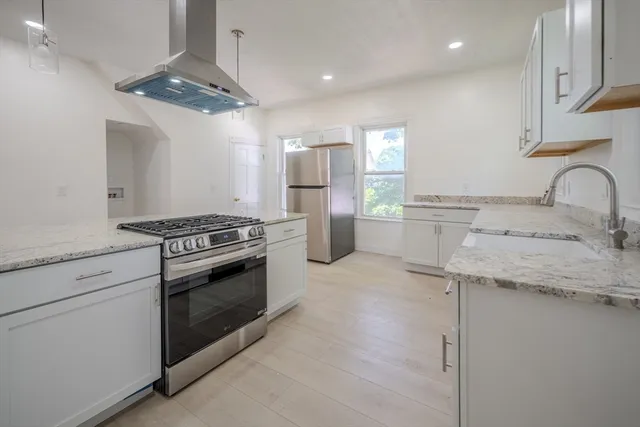 a kitchen with stainless steel appliances granite countertop a sink stove and refrigerator