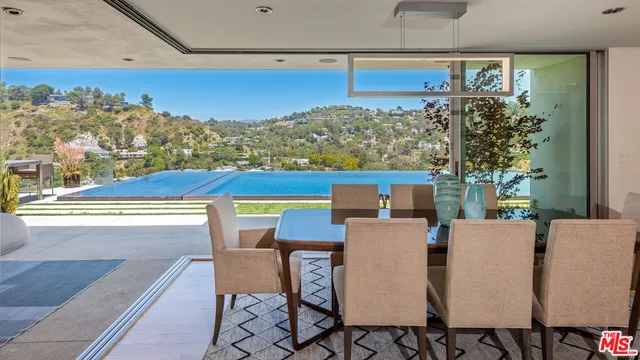 a living room with furniture a flat screen tv and a large window