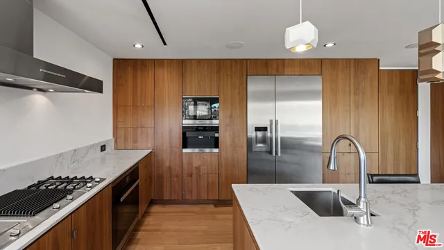 a kitchen with stainless steel appliances a sink and a refrigerator
