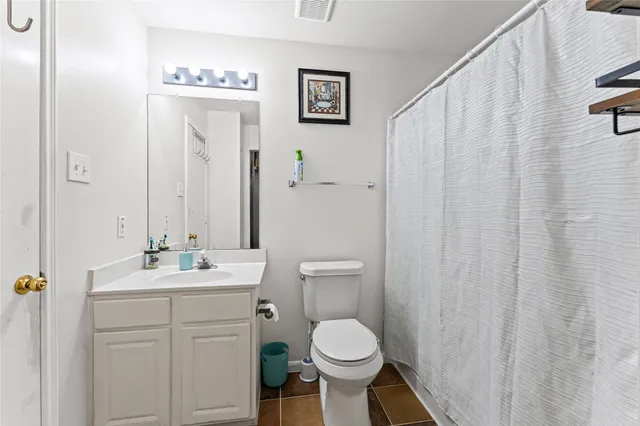 a bathroom with a toilet sink vanity and mirror