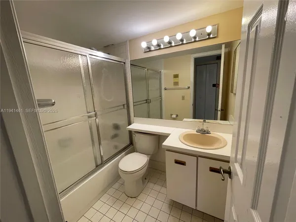 a bathroom with a sink and mirror with toilet