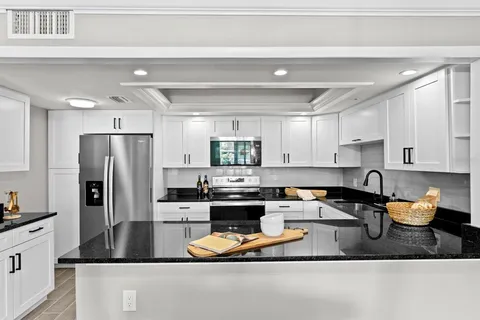 a kitchen with a refrigerator a sink and cabinets