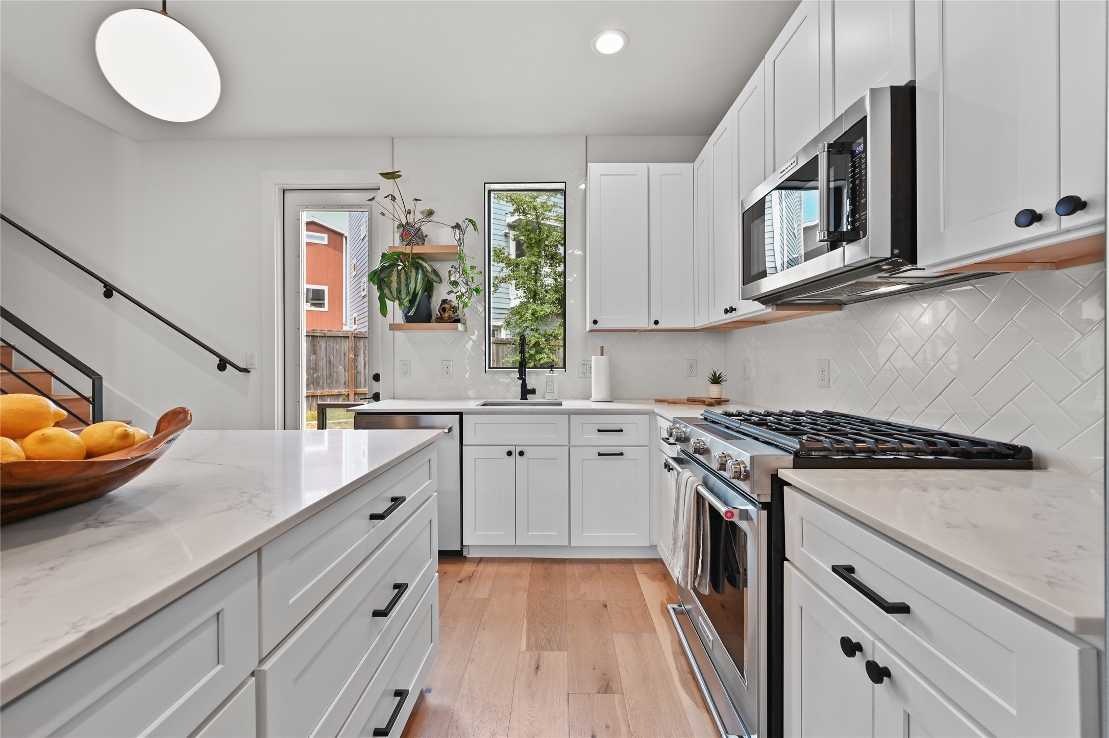 Kitchen with appliances with stainless steel finishes, open shelves, white cabinetry, light wood finished floors, and recessed lighting