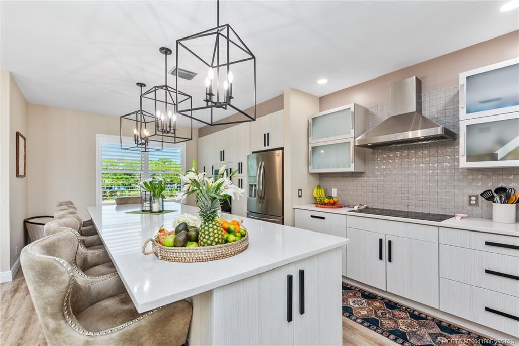 a kitchen with stainless steel appliances kitchen island granite countertop a sink a stove and a refrigerator