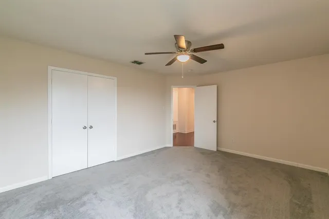 a view of an empty room and a ceiling fan