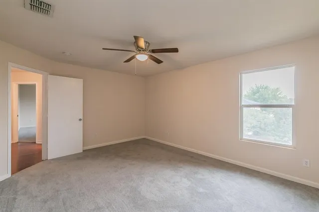 a view of room with a ceiling fan and window