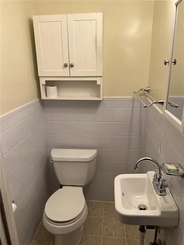 a bathroom with a toilet sink and mirror