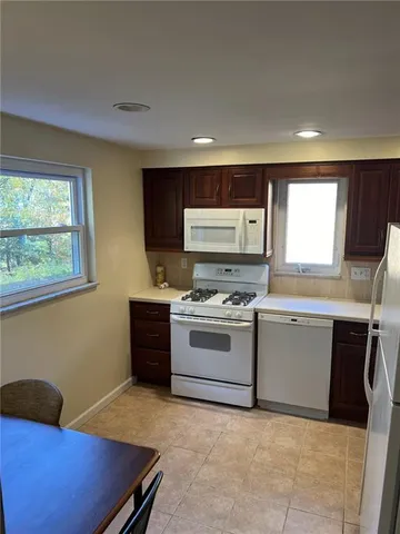 a kitchen with stainless steel appliances kitchen island granite countertop a stove a sink and a microwave