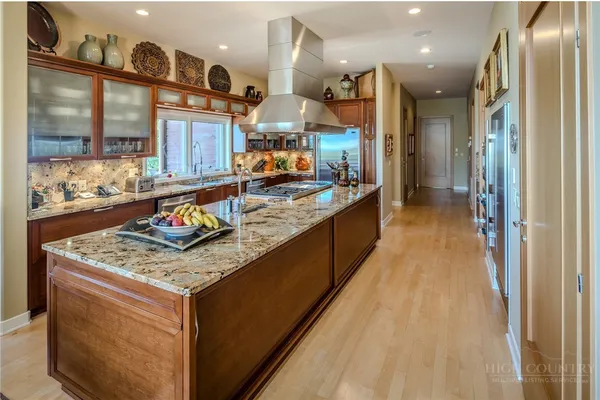 a large kitchen with stainless steel appliances granite countertop a stove a sink and a microwave