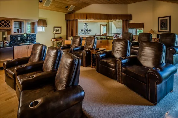 a living room with furniture a flat screen tv and a floor to ceiling window