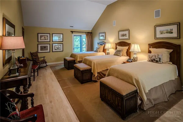 a bed sitting in a bedroom next to a window with lamp