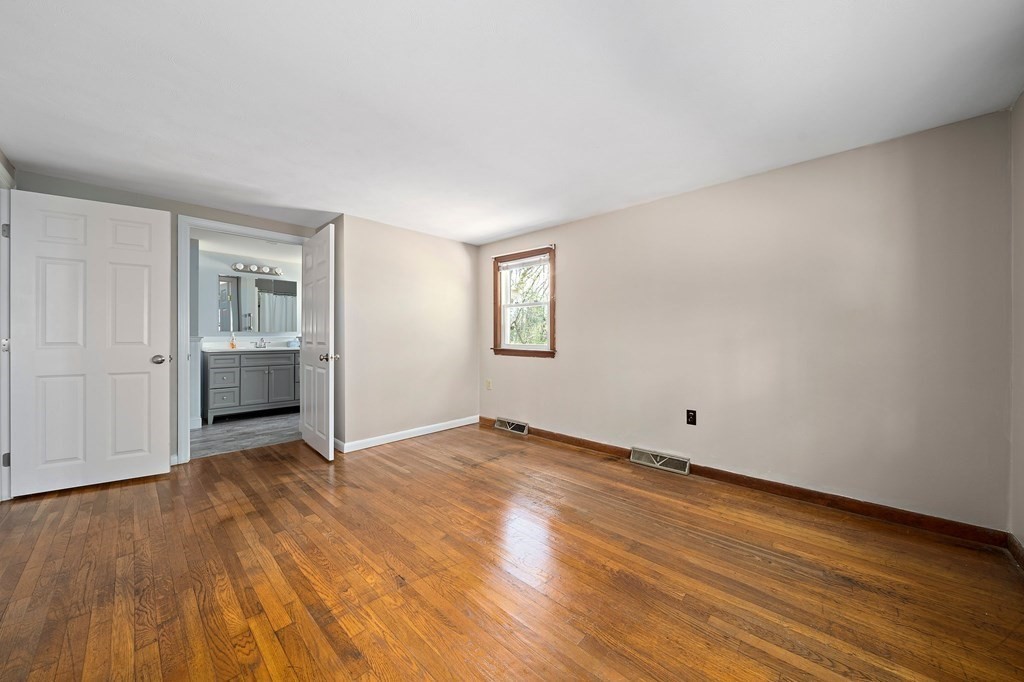 61 Orchard Road Marshfield, MA 02050 - Photo 18 of 33 a view of an empty room with wooden floor and a window
