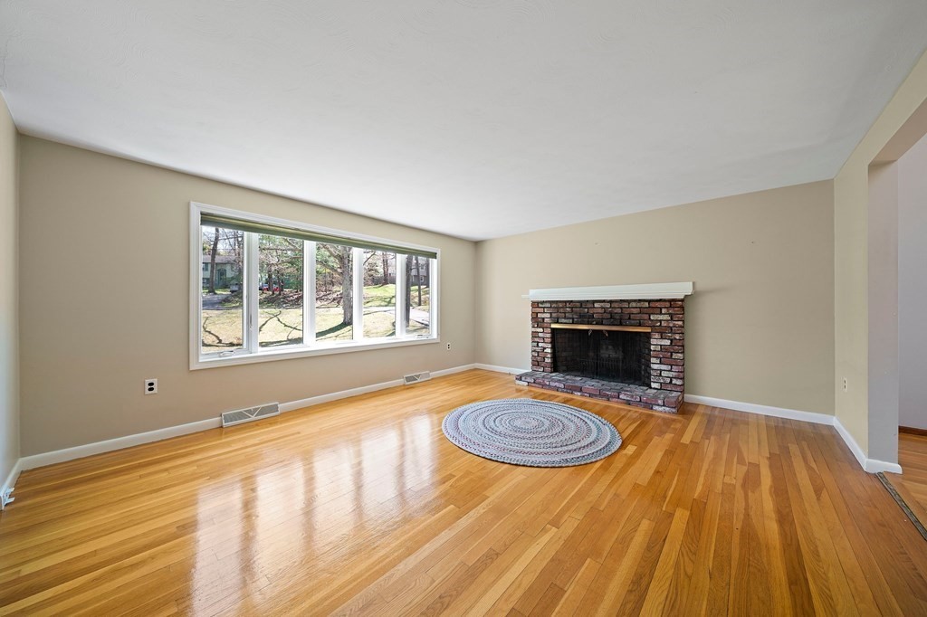 61 Orchard Road Marshfield, MA 02050 - Photo 4 of 33 a view of empty room with wooden floor and fireplace