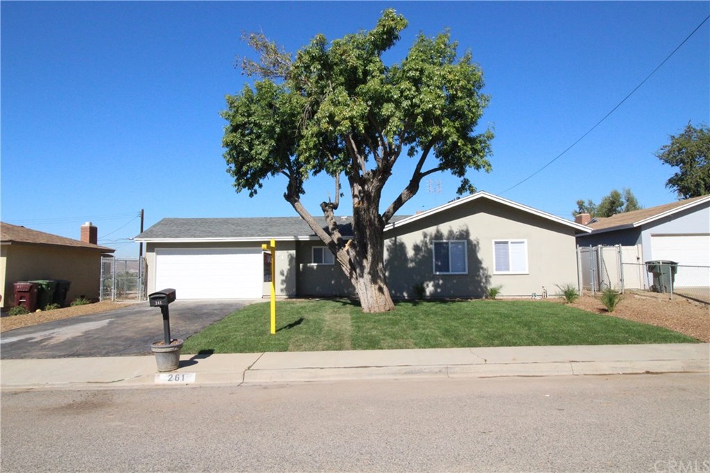 261 Versailles Place Riverside, CA 92501 - Photo 1 of 1 a tree in front of a white house