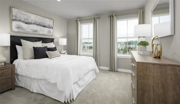 a bedroom with a bed painting on the wall and a window