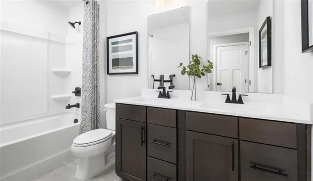 a bathroom with a toilet a sink a mirror a bathtub and vanity