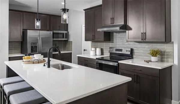 a kitchen with stainless steel appliances a sink a stove and refrigerator