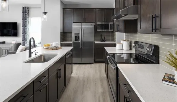 a kitchen with stainless steel appliances granite countertop a sink a stove and a refrigerator