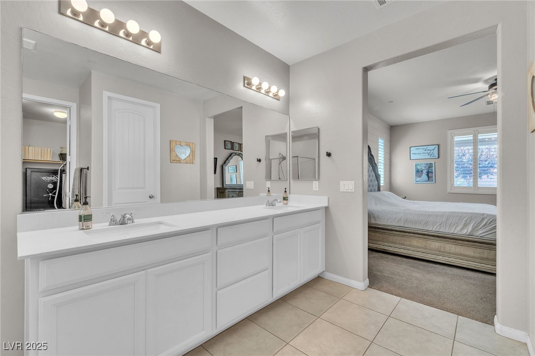 119 Mosso Niente Place Henderson, NV 89011 - Photo 17 of 36 Ensuite bathroom with double vanity, light tile patterned floors, a ceiling fan, and light carpet