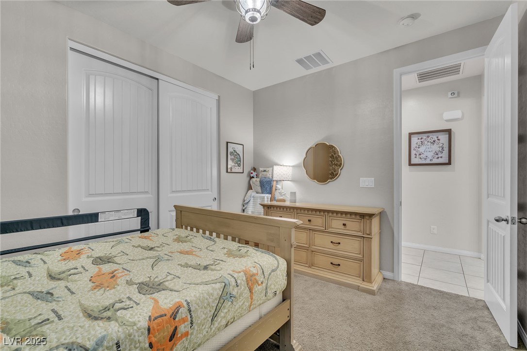 119 Mosso Niente Place Henderson, NV 89011 - Photo 24 of 36 Bedroom featuring light colored carpet, a closet, and a ceiling fan