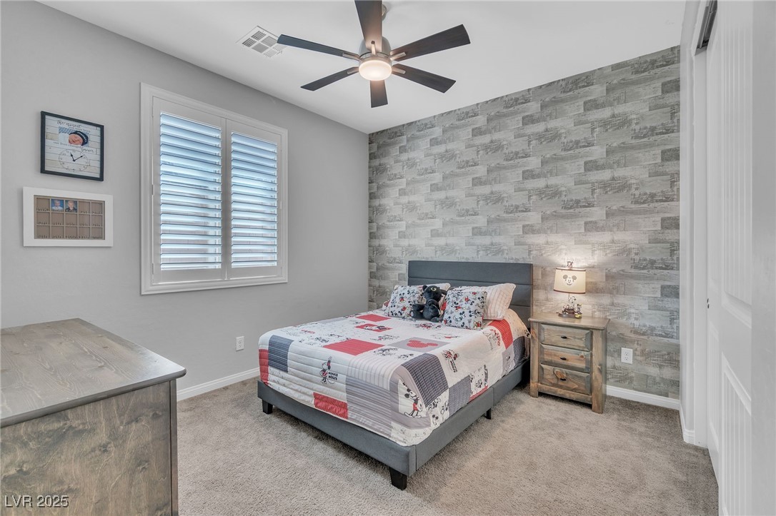 119 Mosso Niente Place Henderson, NV 89011 - Photo 26 of 36 Bedroom featuring an accent wall, wallpapered walls, light colored carpet, and ceiling fan