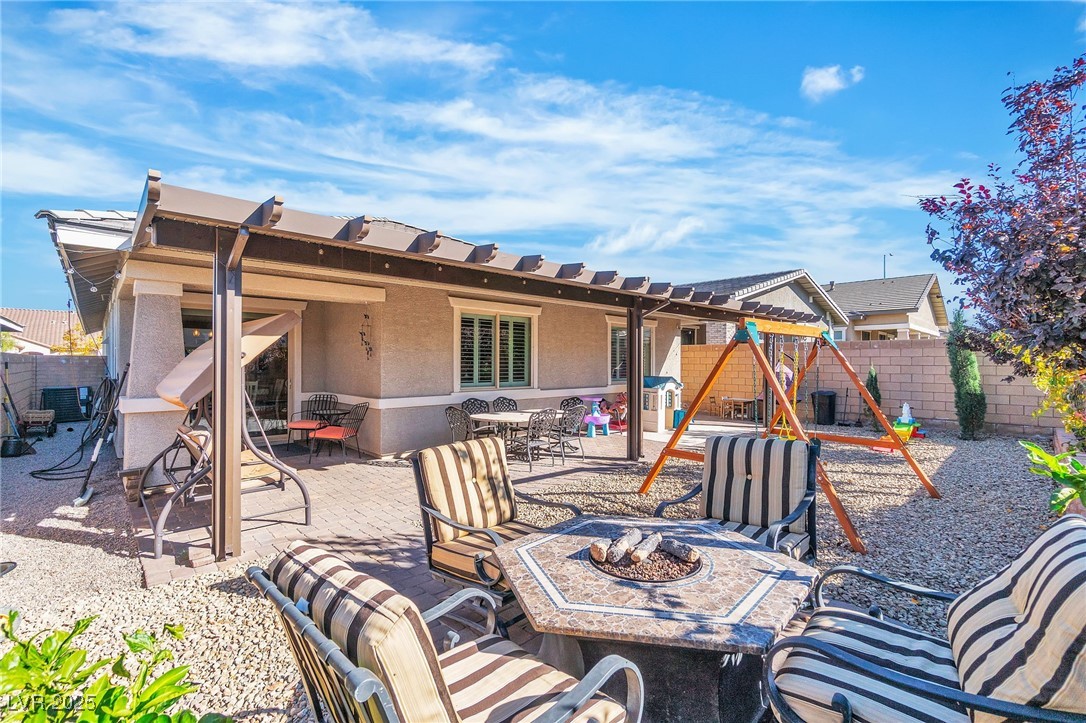 119 Mosso Niente Place Henderson, NV 89011 - Photo 29 of 36 Fenced backyard with a patio, an outdoor fire pit, a pergola, and a playground