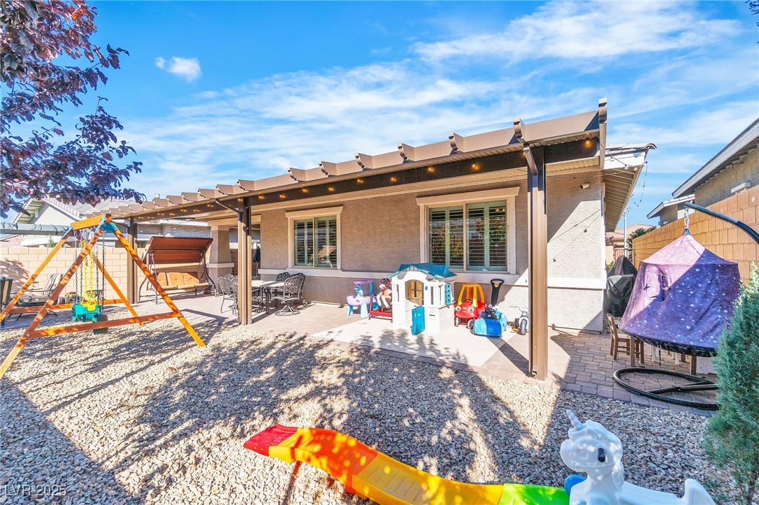 119 Mosso Niente Place Henderson, NV 89011 - Photo 30 of 36 Back of property featuring a fenced backyard, a playground, a patio, a pergola, and stucco siding
